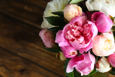 Photo of Bouquet of beautiful fresh peonies on wooden background, closeup