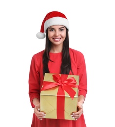 Happy young woman in Santa hat holding Christmas gift on white background