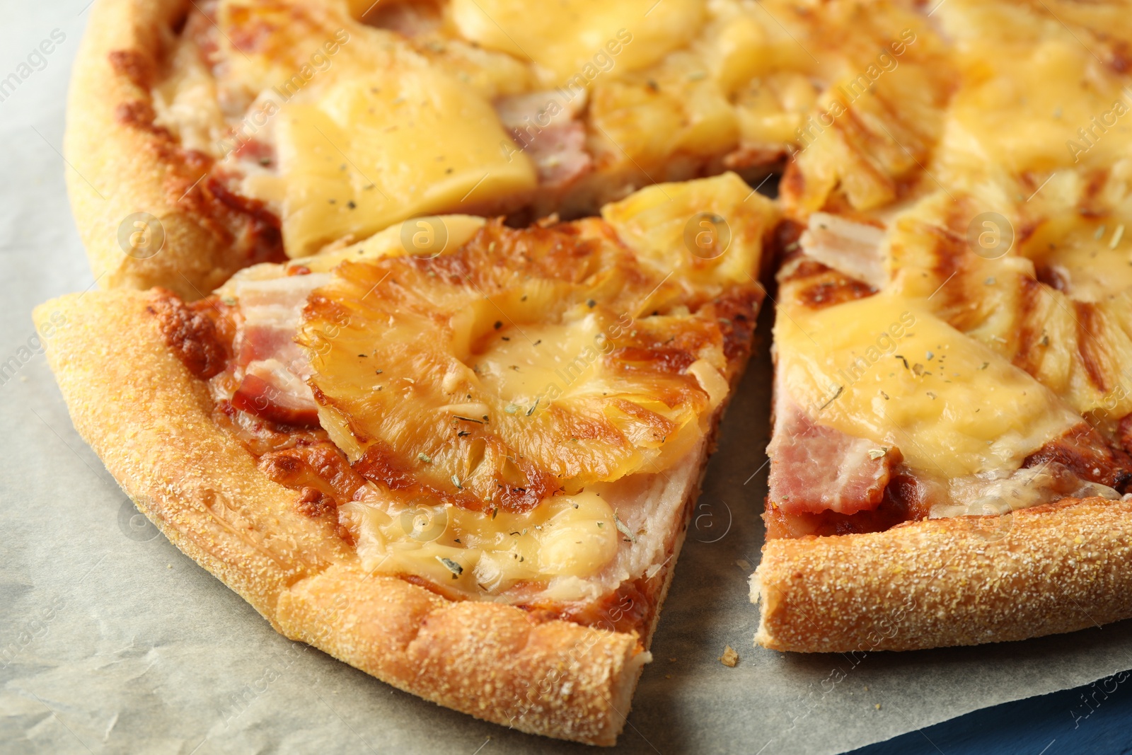 Photo of Delicious cut pineapple pizza on table, closeup