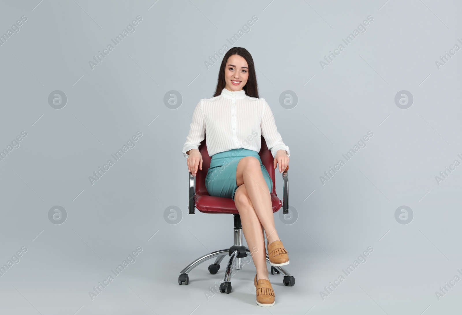 Photo of Young businesswoman sitting in comfortable office chair on grey background