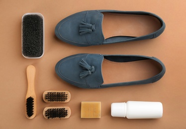 Stylish footwear with shoe care accessories on brown background, flat lay