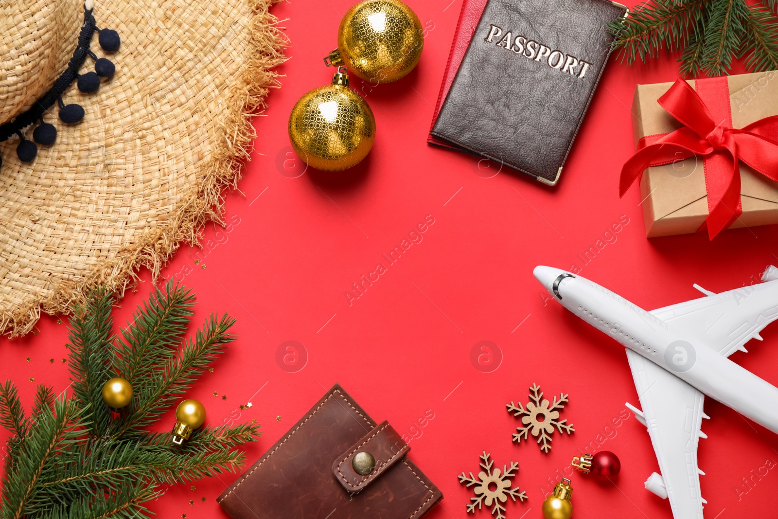 Photo of Frame of Christmas decorations, passports and space for text on red background, flat lay. Winter vacation