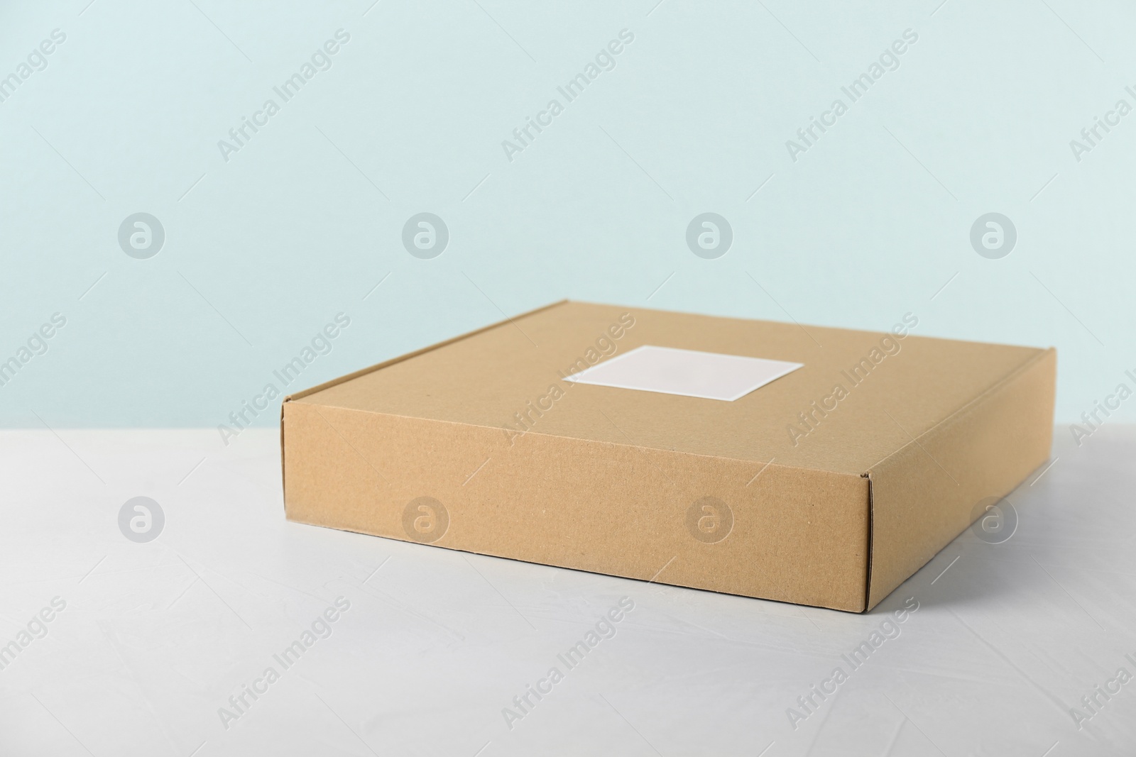 Photo of Cardboard box on table against light background