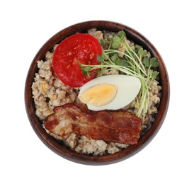 Delicious boiled oatmeal with egg, bacon and tomato in bowl isolated on white, top view