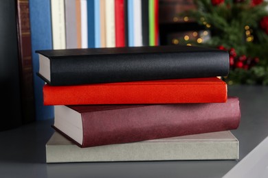 Stack of hardcover books on grey table indoors, closeup