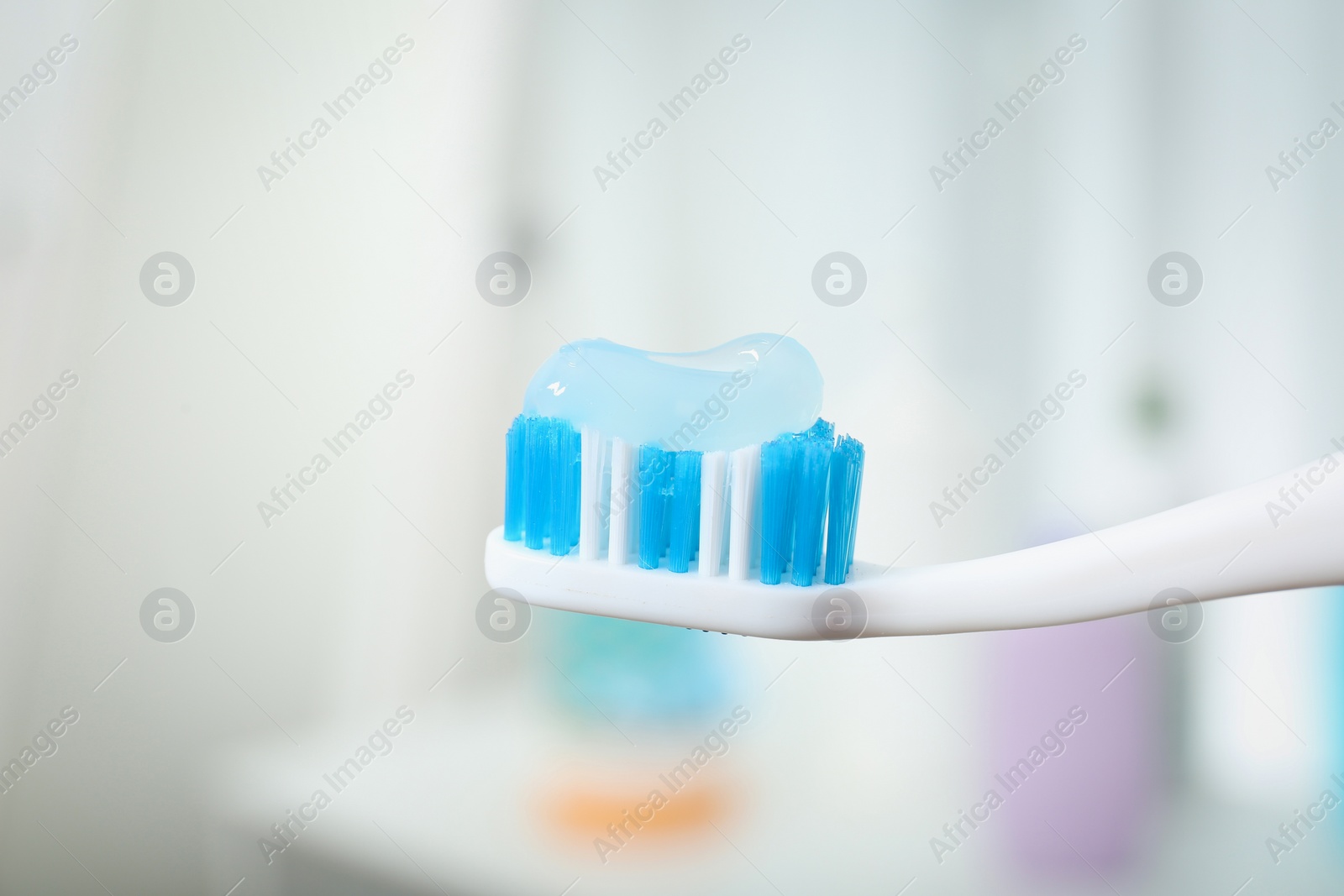 Photo of Brush with toothpaste on blurred background, closeup