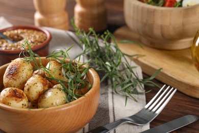 Photo of Delicious grilled potatoes with tarragon served on table