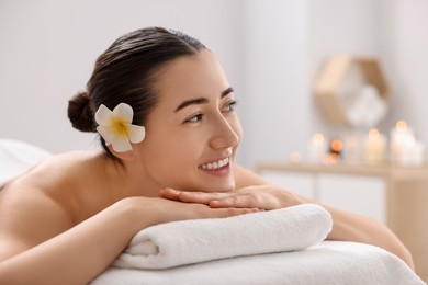 Photo of Beautiful woman relaxing on massage couch in spa salon, space for text