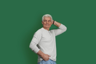 Photo of Portrait of handsome mature man on color background