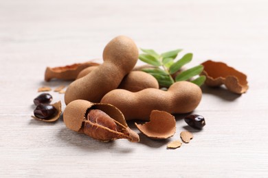 Delicious ripe tamarinds on white wooden table