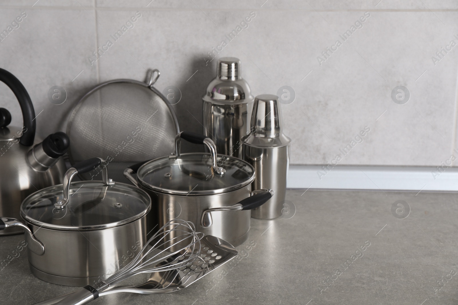 Photo of Set of different cooking utensils on grey countertop in kitchen. Space for text