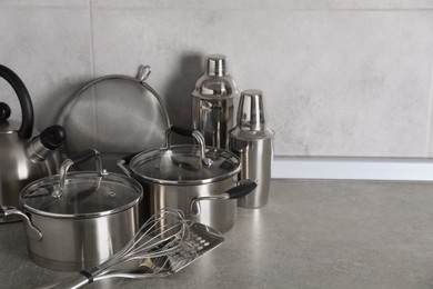Photo of Set of different cooking utensils on grey countertop in kitchen. Space for text