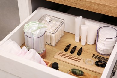 Photo of Open cabinet drawer with tampons and feminine hygiene products
