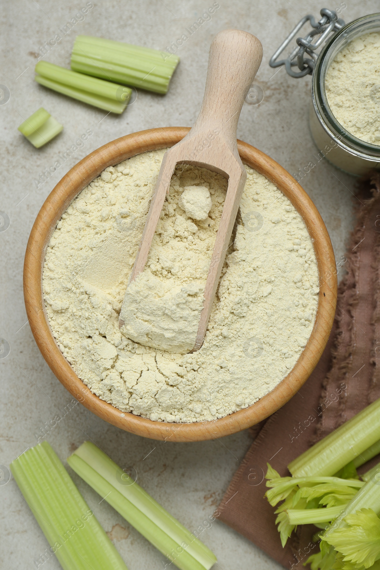 Photo of Natural celery powder and fresh stalks on grey table, flat lay