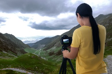 Image of Photographer taking picture of beautiful mountains on cloudy day
