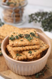 Photo of Cereal crackers with flax, sesame seeds and thyme in bowl on table, closeup