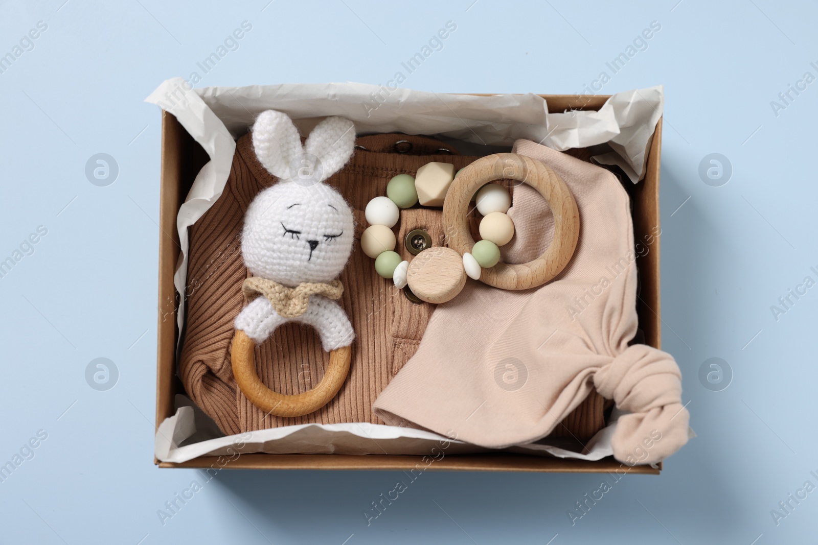 Photo of Different baby accessories in box on light blue background, top view