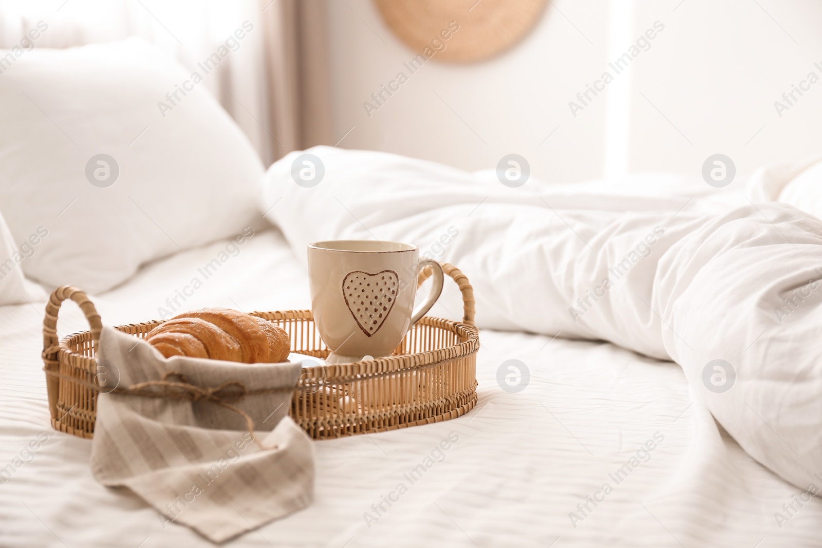 Photo of Delicious morning coffee and croissant on bed