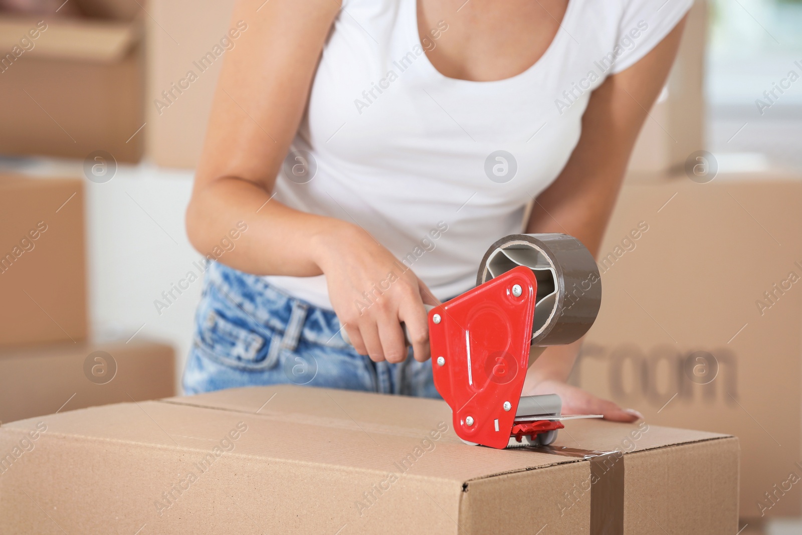 Photo of Woman packing box indoors, closeup. Moving day