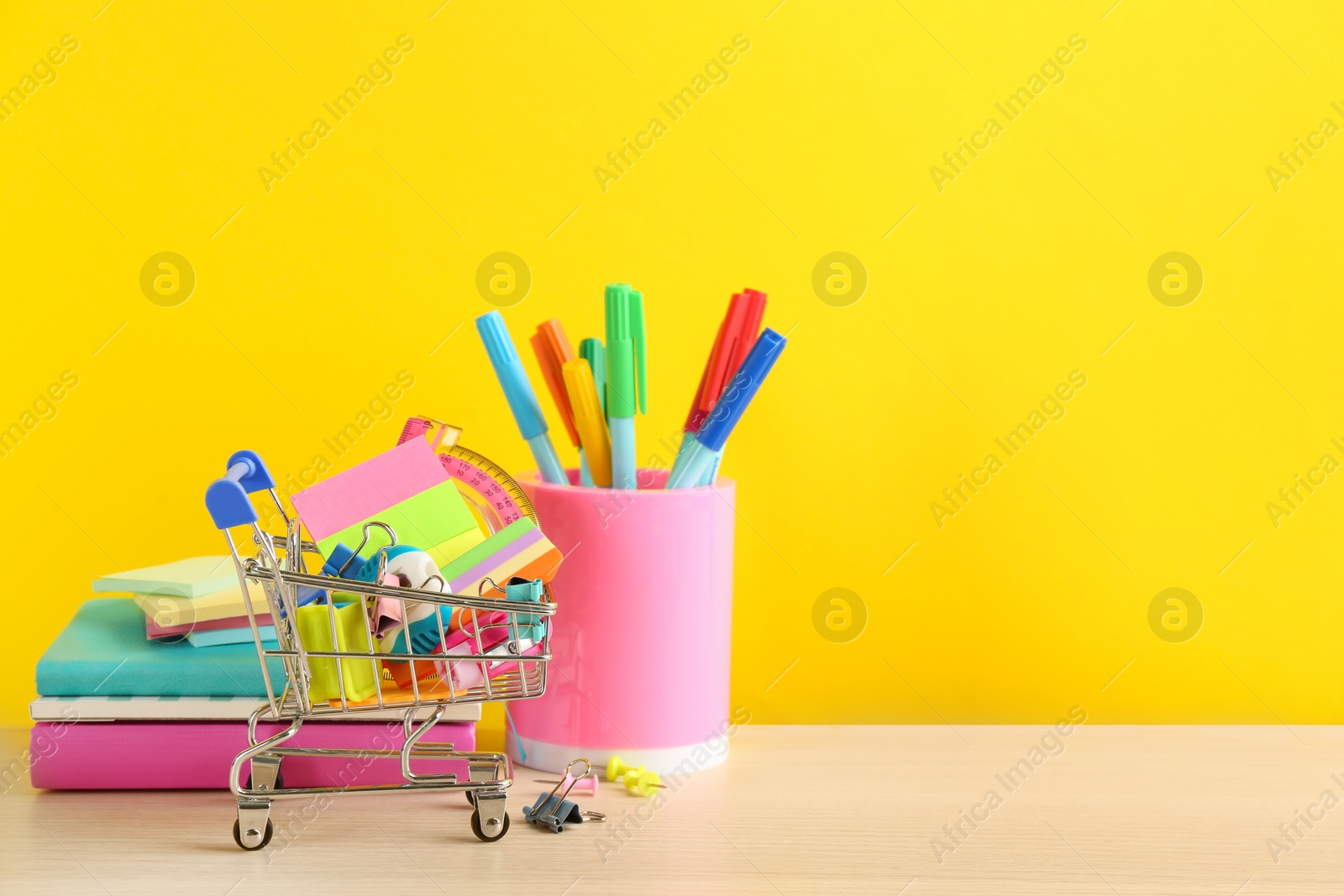 Photo of Different school stationery on table against yellow background, space for text. Back to school