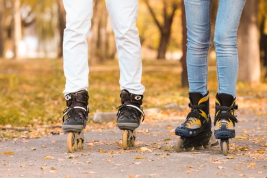 Photo of Couple roller skating in autumn park. Active leisure