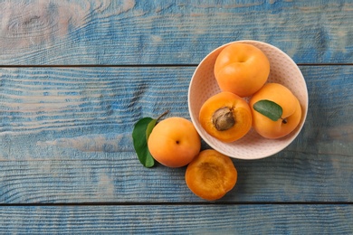 Photo of Composition with delicious apricots on blue wooden background, top view. Space for text