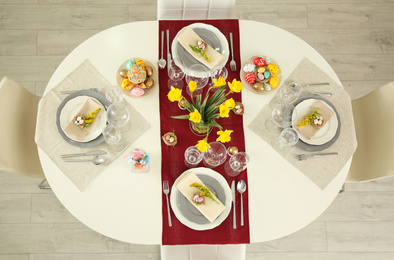 Photo of Festive Easter table setting with floral decor, flat lay