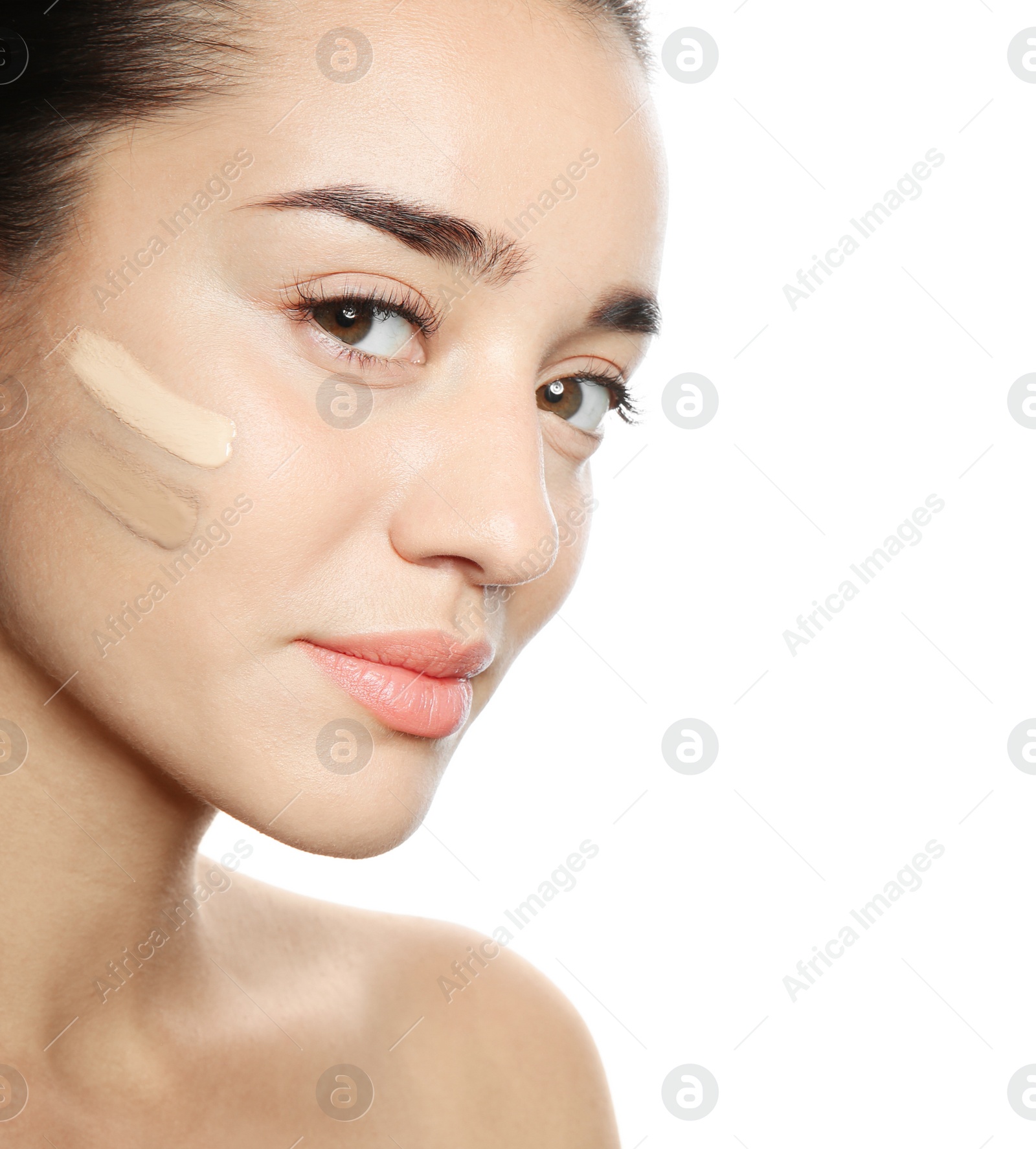 Photo of Young woman with different shades of skin foundation on her face against white background