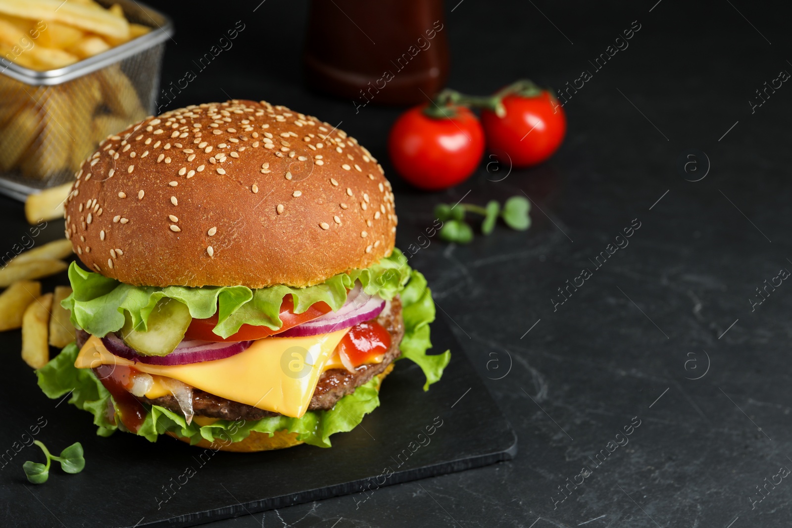 Photo of Delicious burger with beef patty on dark table, space for text