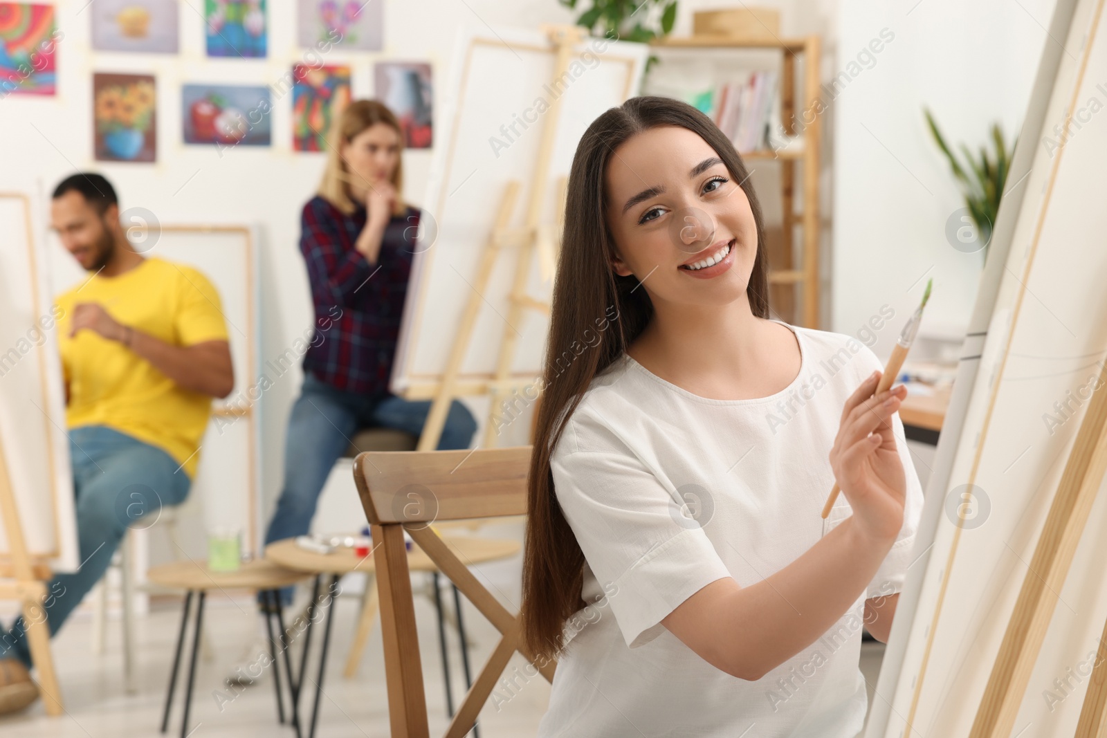 Photo of Group of students attending painting class in studio. Creative hobby