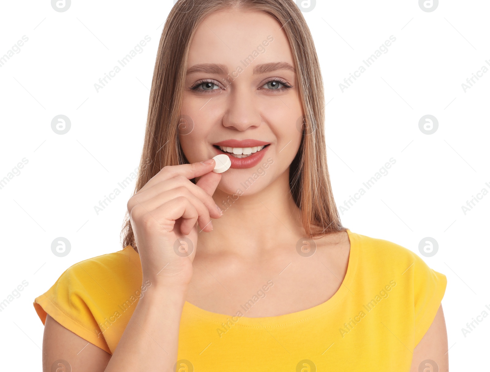 Photo of Young woman taking vitamin pill on white background