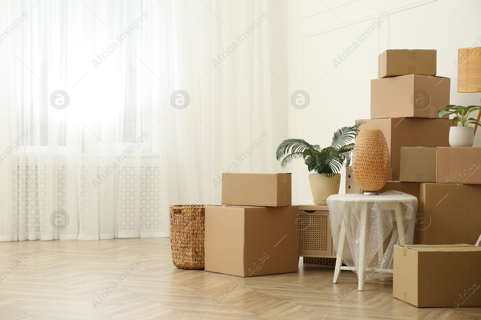 Photo of Cardboard boxes and household stuff indoors, space for text. Moving day