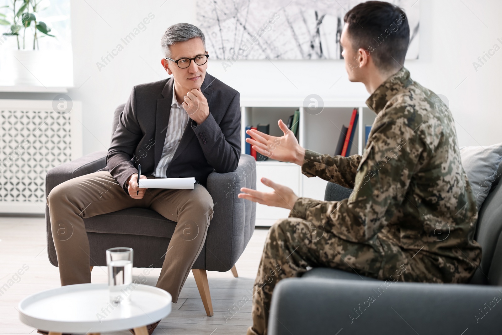 Photo of Professional psychotherapist working with military man in office