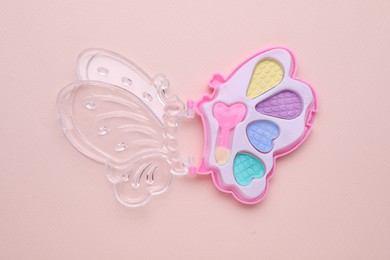 Photo of Decorative cosmetics for kids. Eye shadow palette on pink background, top view