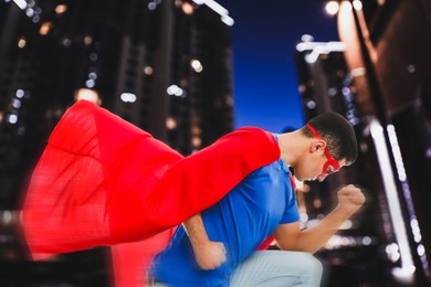 Man wearing superhero costume and beautiful cityscape in night on background
