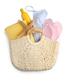 Stylish knitted bag with different beach accessories on white background, top view