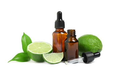 Photo of Lime essential oil in bottles and citrus fruits isolated on white