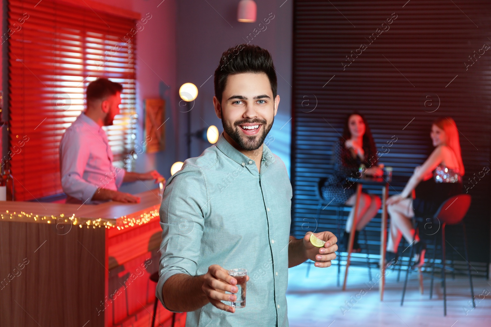 Photo of Young man with Mexican Tequila shot in bar