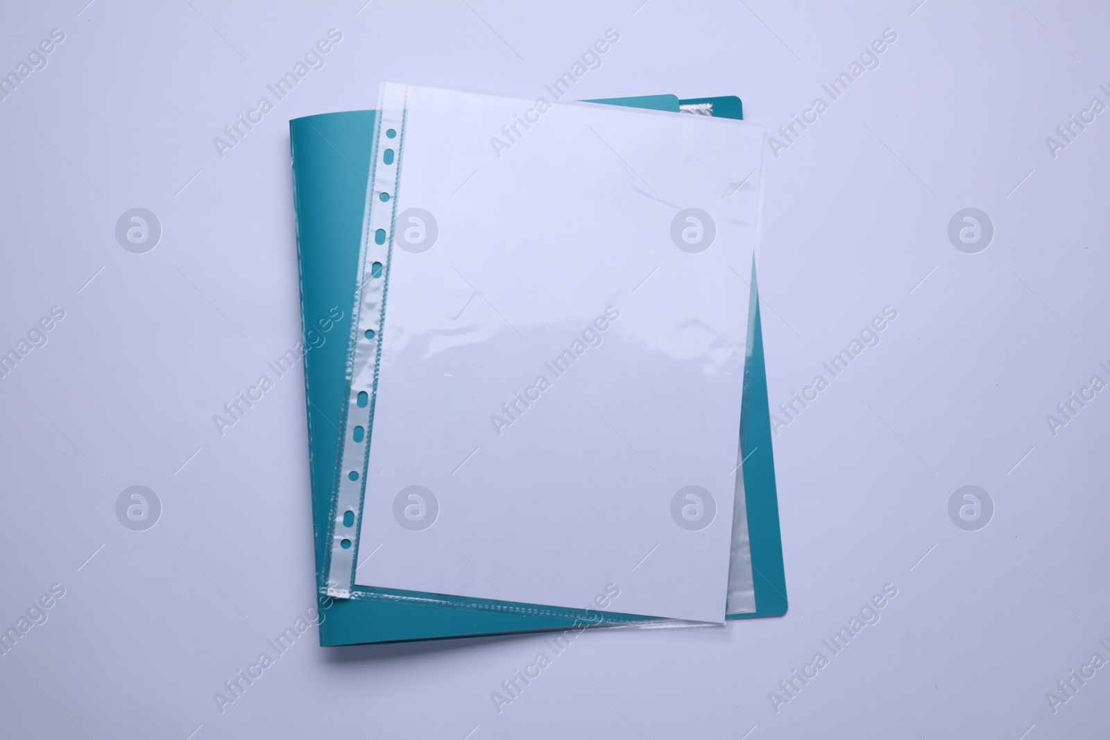 Photo of File folder with punched pockets and paper sheets isolated on white, top view