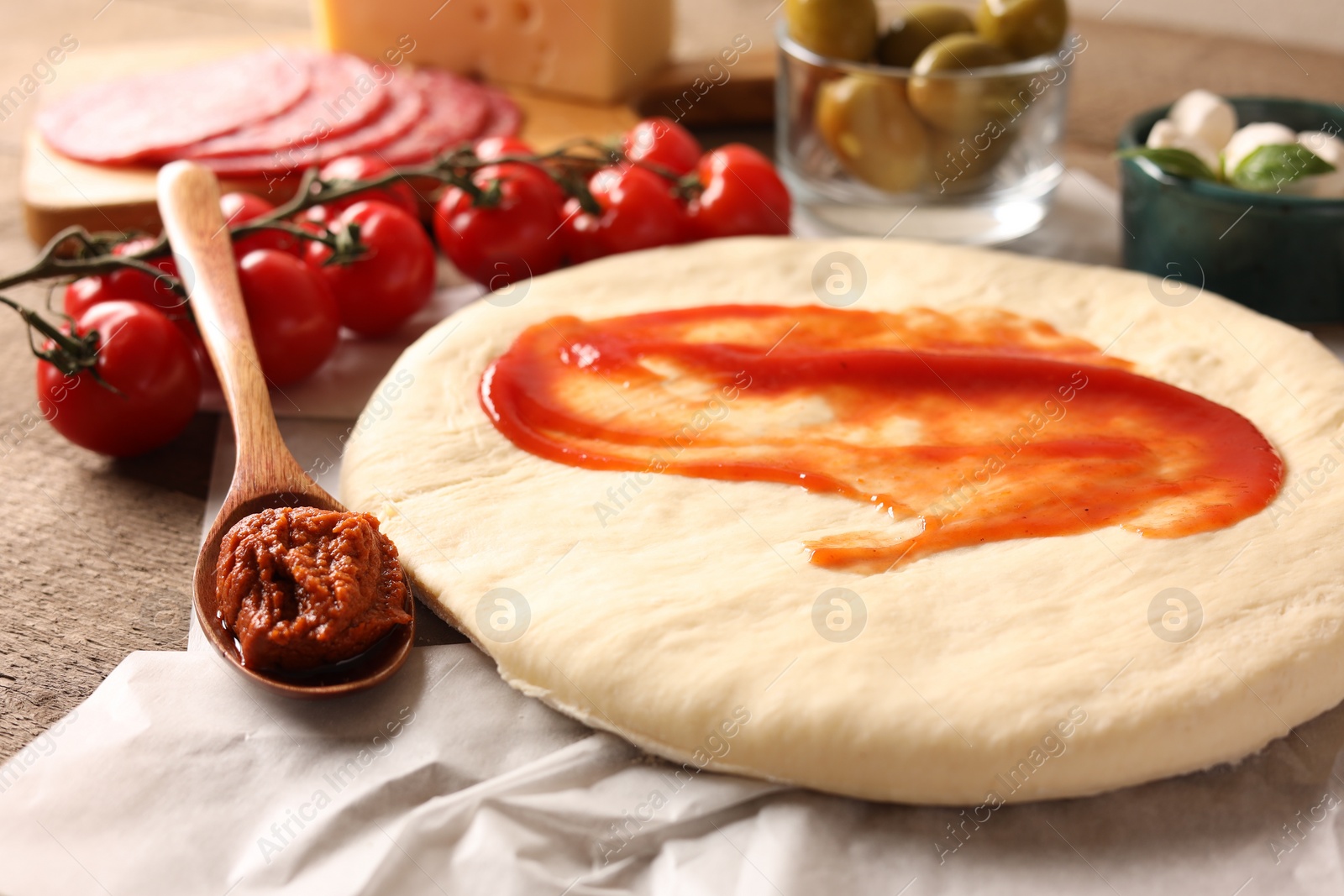 Photo of Pizza dough and products on table, closeup