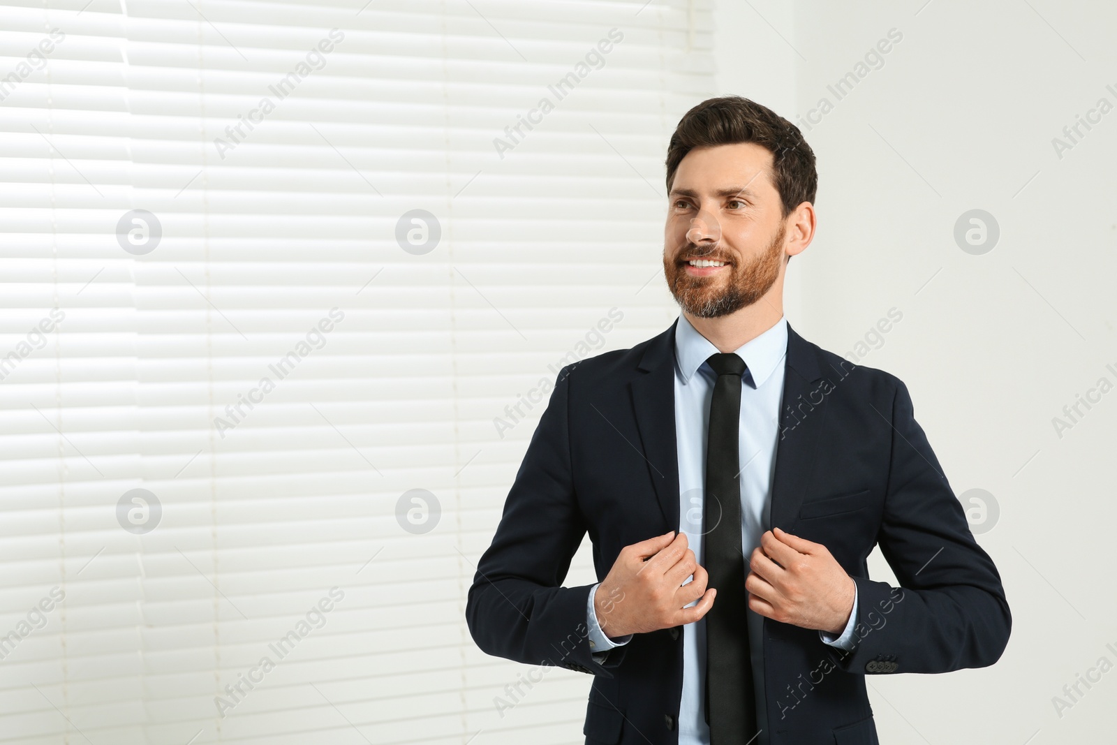 Photo of Handsome real estate agent in nice suit indoors, space for text