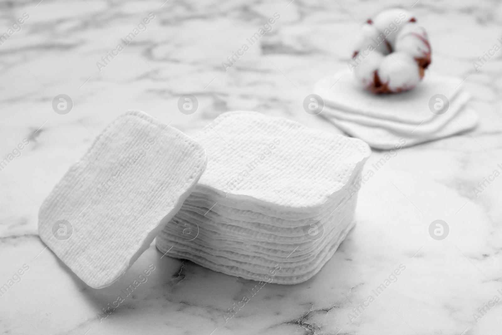 Photo of Stack of clean cotton pads on white marble table