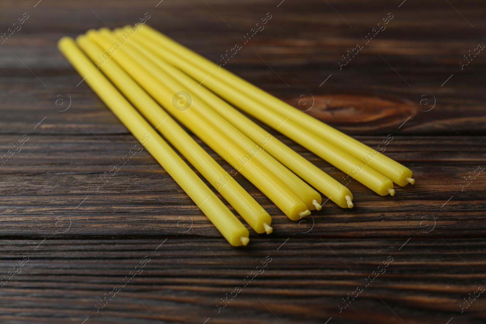 Photo of Many church candles on wooden table, closeup