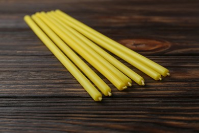Many church candles on wooden table, closeup