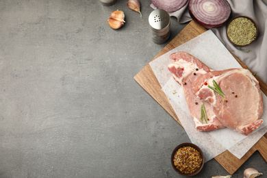 Photo of Flat lay composition with fresh beef cut on grey table. Space for text