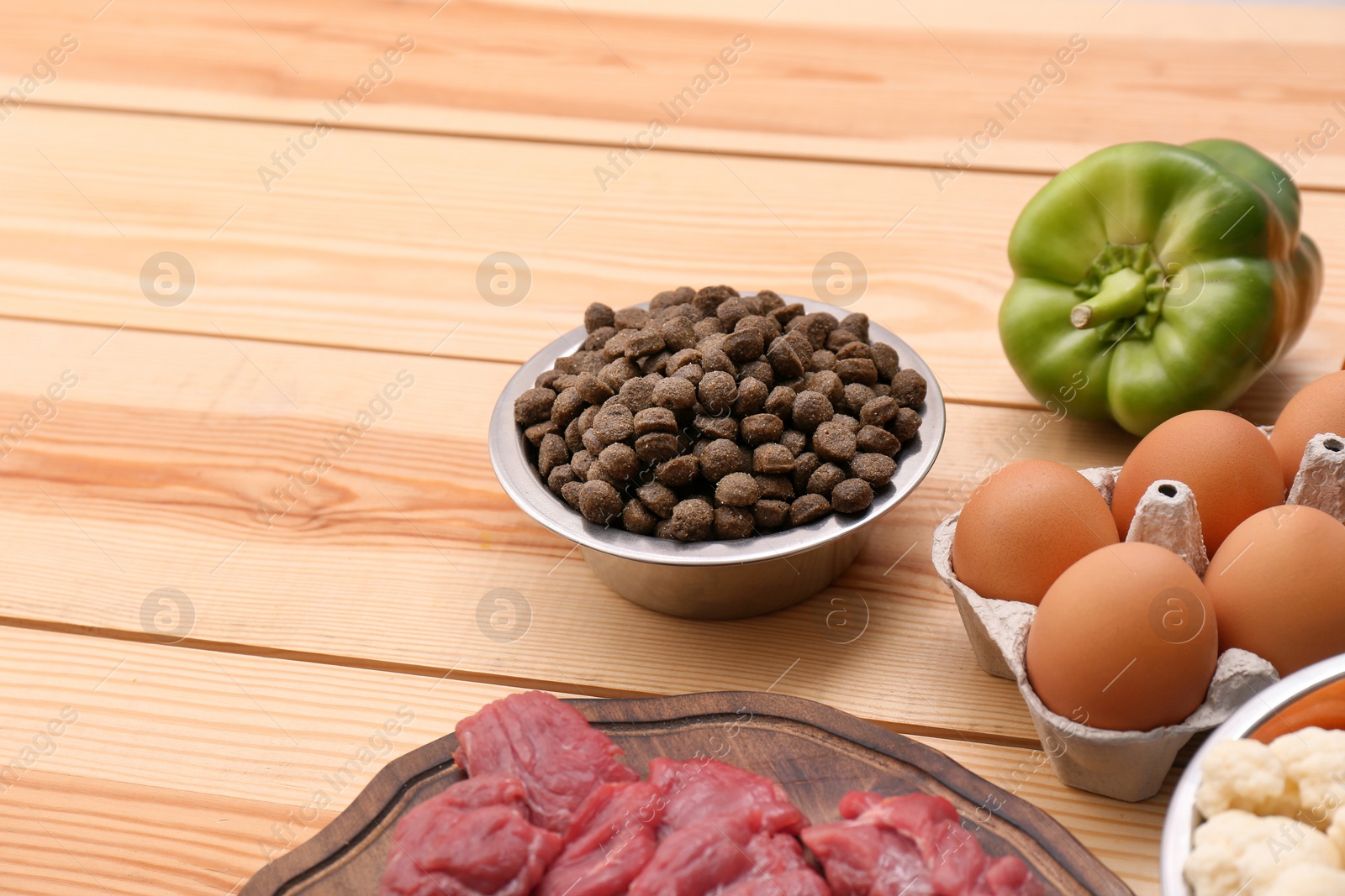 Photo of Composition with dry and natural dog food on wooden background