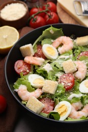 Delicious Caesar salad with shrimps on table, closeup