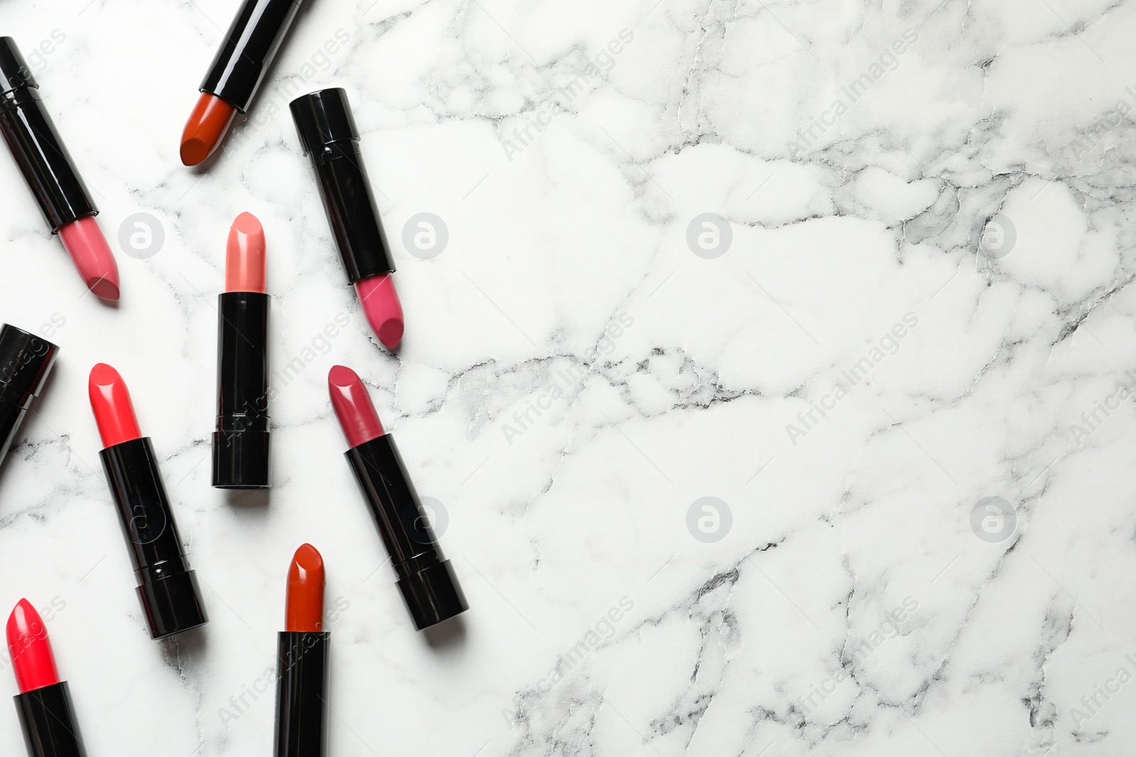 Photo of Different lipsticks and space for text on marble background, flat lay