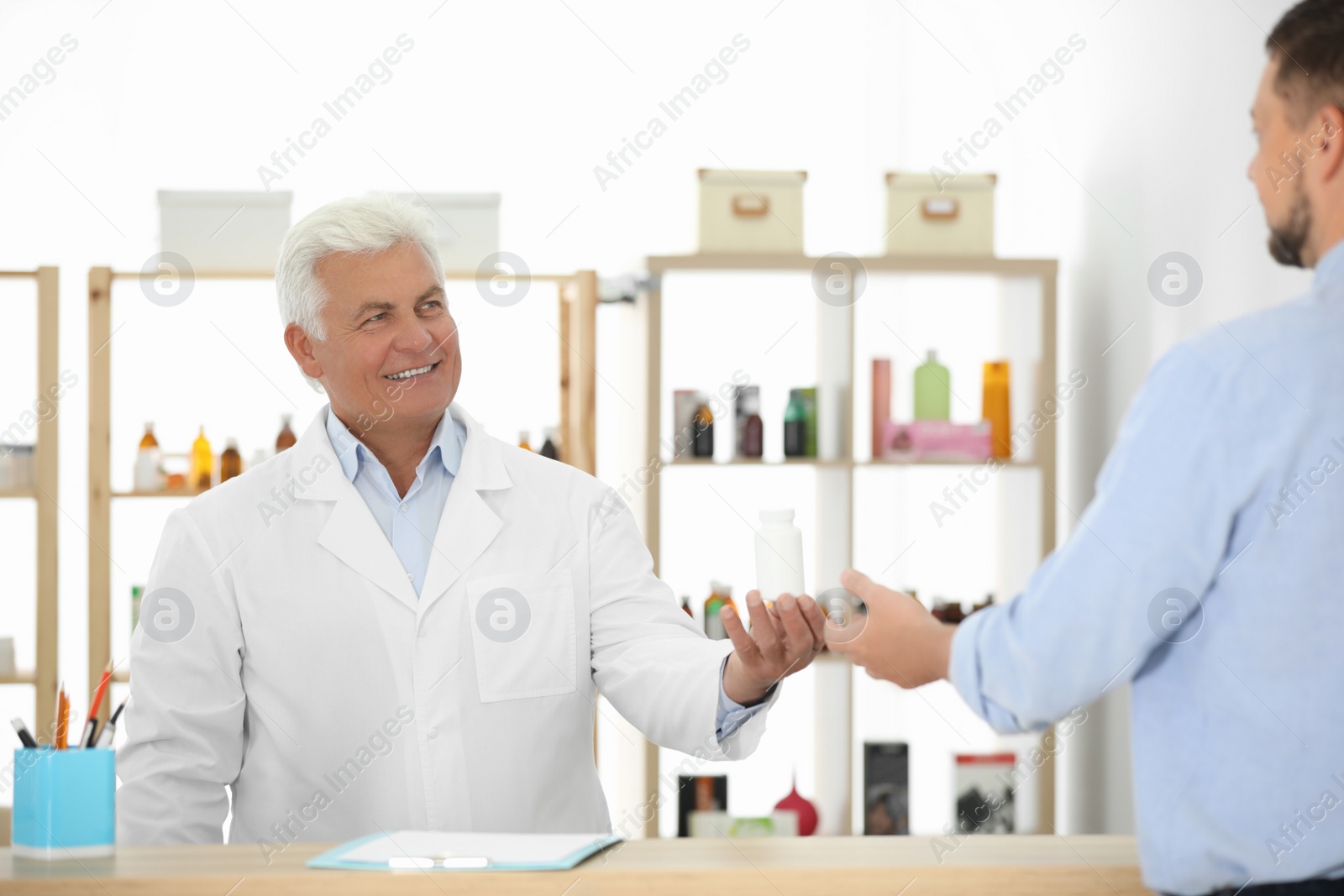 Photo of Pharmacist giving medicine to customer in drugstore