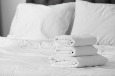 Photo of Stack of clean white towels on bed